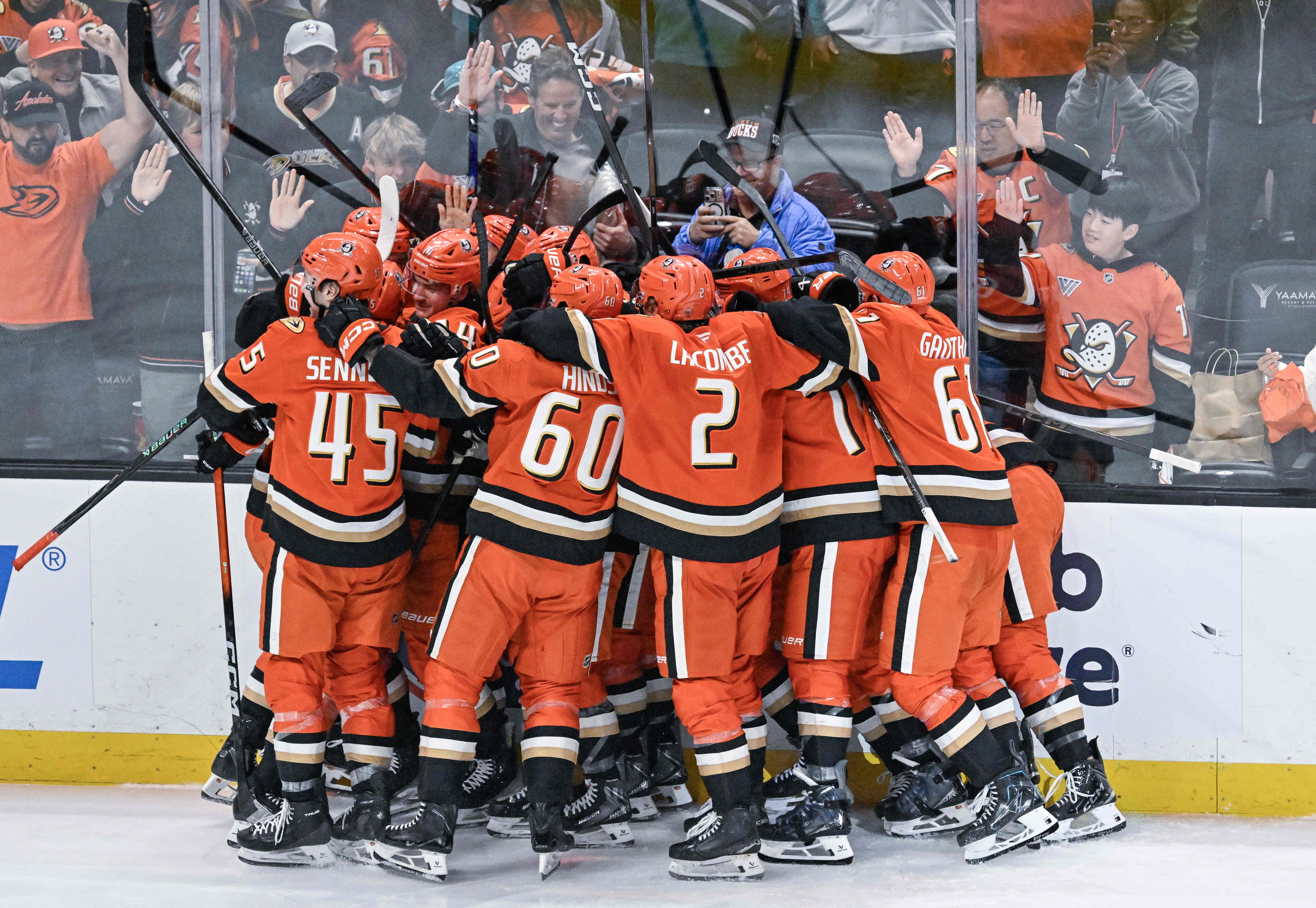 Ducks players celebrate their overtime 4-3 win, after a lengthy...