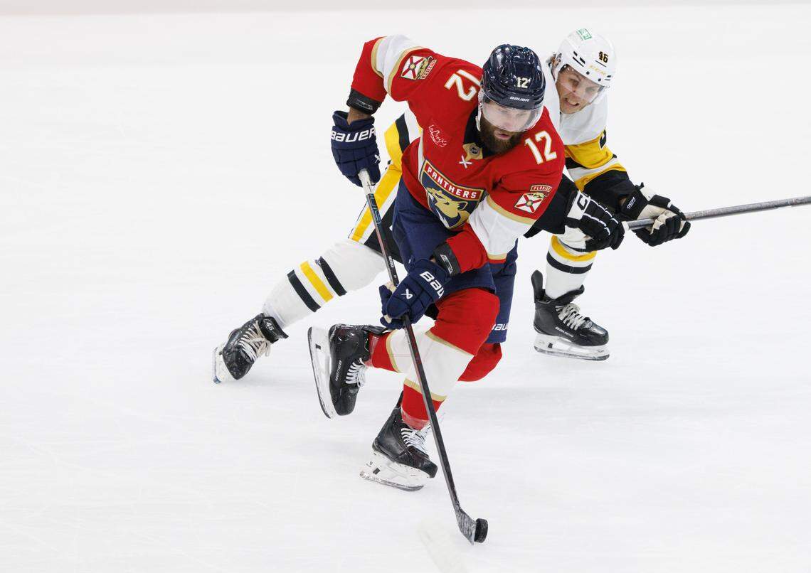 Florida Panthers left wing Jonah Gadjovich (12) tries to keep the puck from Pittsburgh Penguins center Blake Lizotte (46) during the second period of a game on Thursday, Oct. 23, 2025, at Amerant Bank Arena in Sunrise, Fla.
