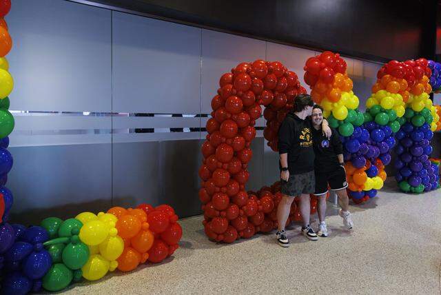 Austin Lee, left, kisses Nate Cooper as they pose for a photo in Heated Rivalry themed sweatshirts during Florida Panthers Pride Night on Tuesday, March 31, 2026, at Amerant Bank Arena in Sunrise, Fla.