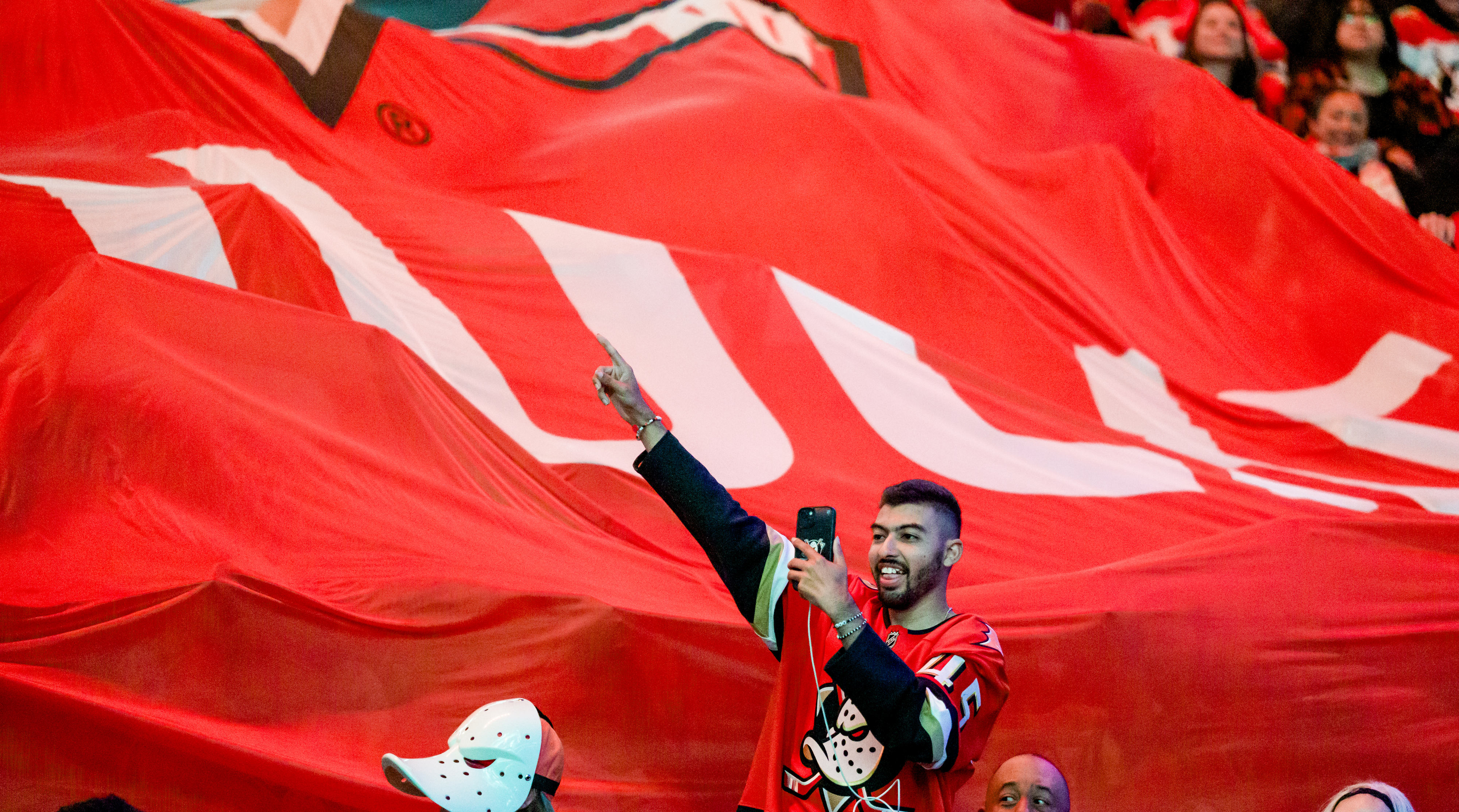 A fan takes a selfie as a giant banner is...