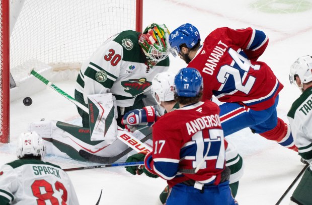 Montreal Canadiens' Phillip Danault (24) scores on Minnesota Wild goaltender Jesper Wallstedt (30) during the first period of an NHL hockey game in Montreal, Tuesday, Jan. 20, 2026. (Christinne Muschi/The Canadian Press via AP)
