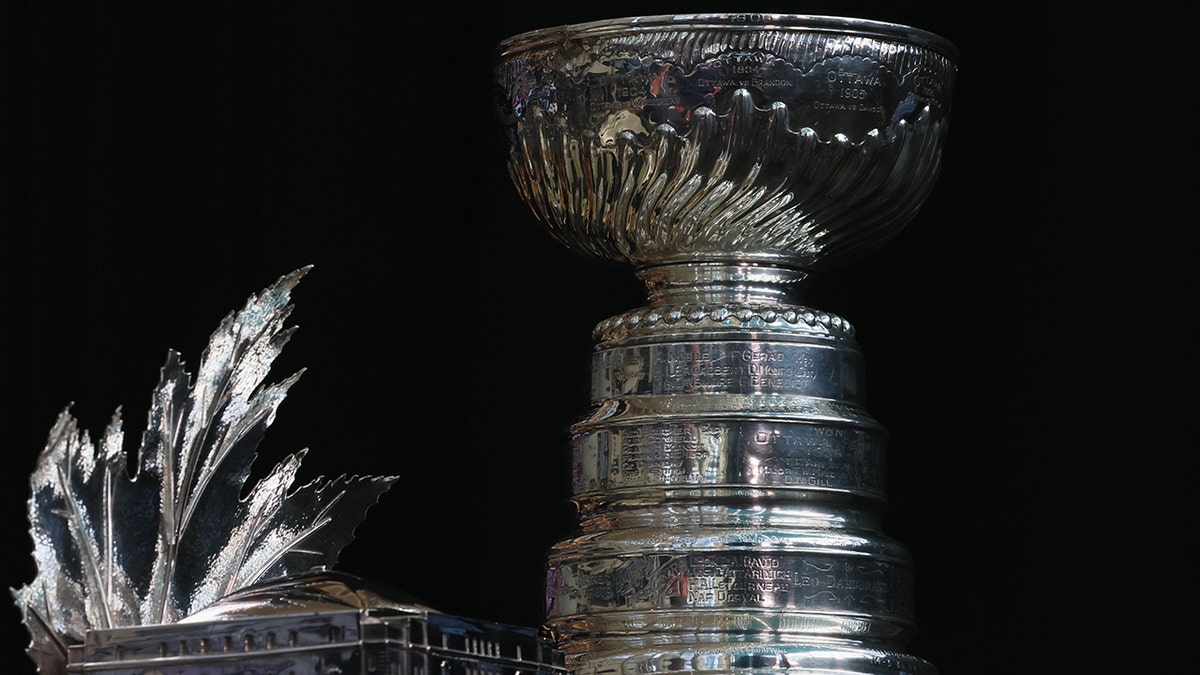 Conn Smythe Trophy and Stanley Cup displayed on a table at Ball Arena in Denver