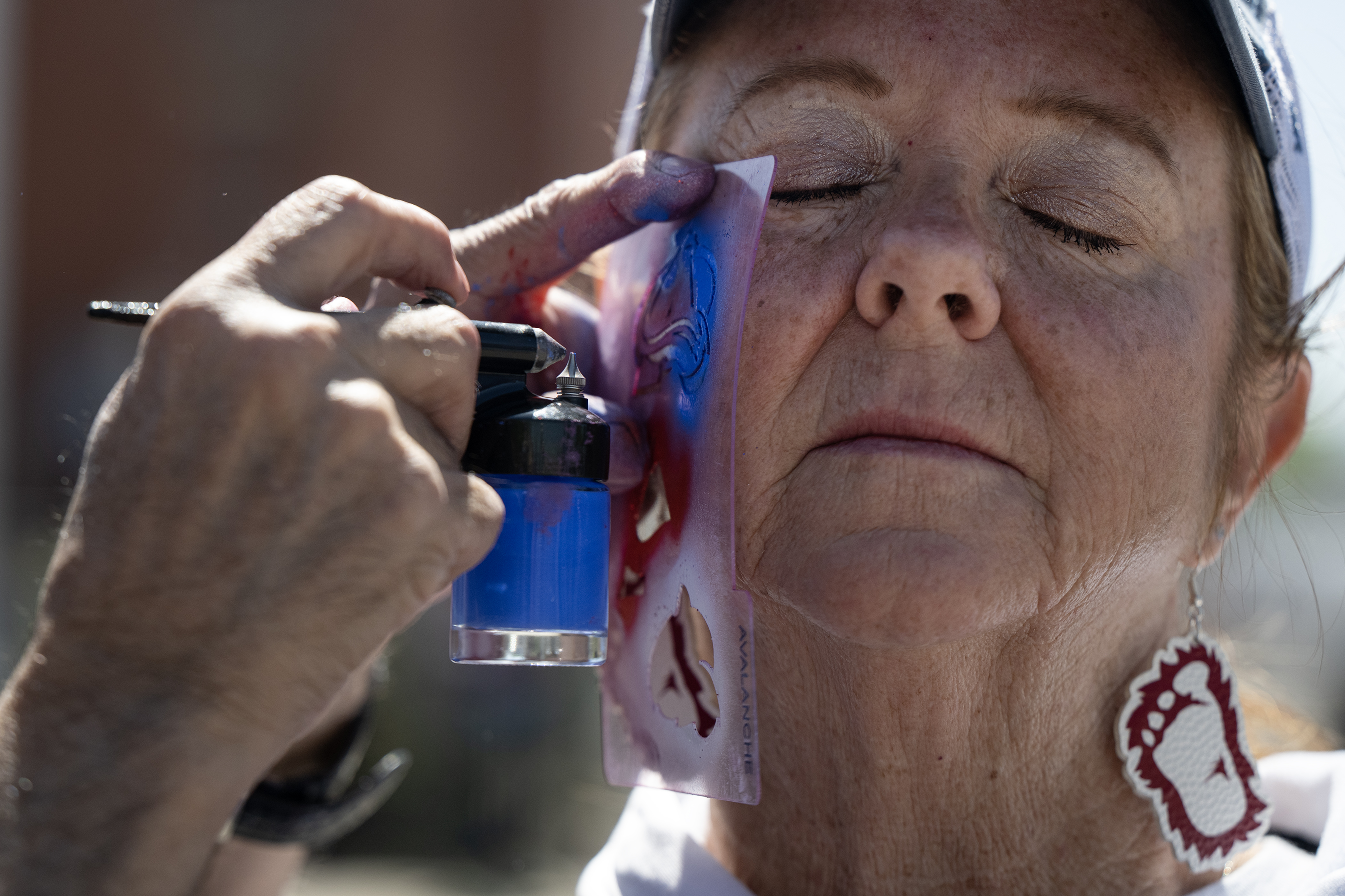 Colorado Avalanche fan Cyndee Whitmarsh gets an Avs logo painted...