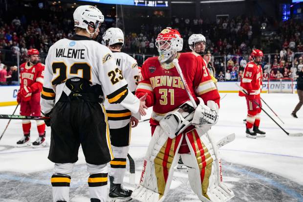 Western Michigan Broncos forward Liam Valente (23) and Denver Pioneers goaltender Johnny Hicks (31) shake hands after the game at Blue FCU Arena on Sunday, March 29, 2026, in Loveland, Colo. Denver Pioneers beat the Western Michigan Broncos 6-2 in the NCAA Regional Playoff game. (Photo by Rebecca Slezak/Special to The Denver Post)