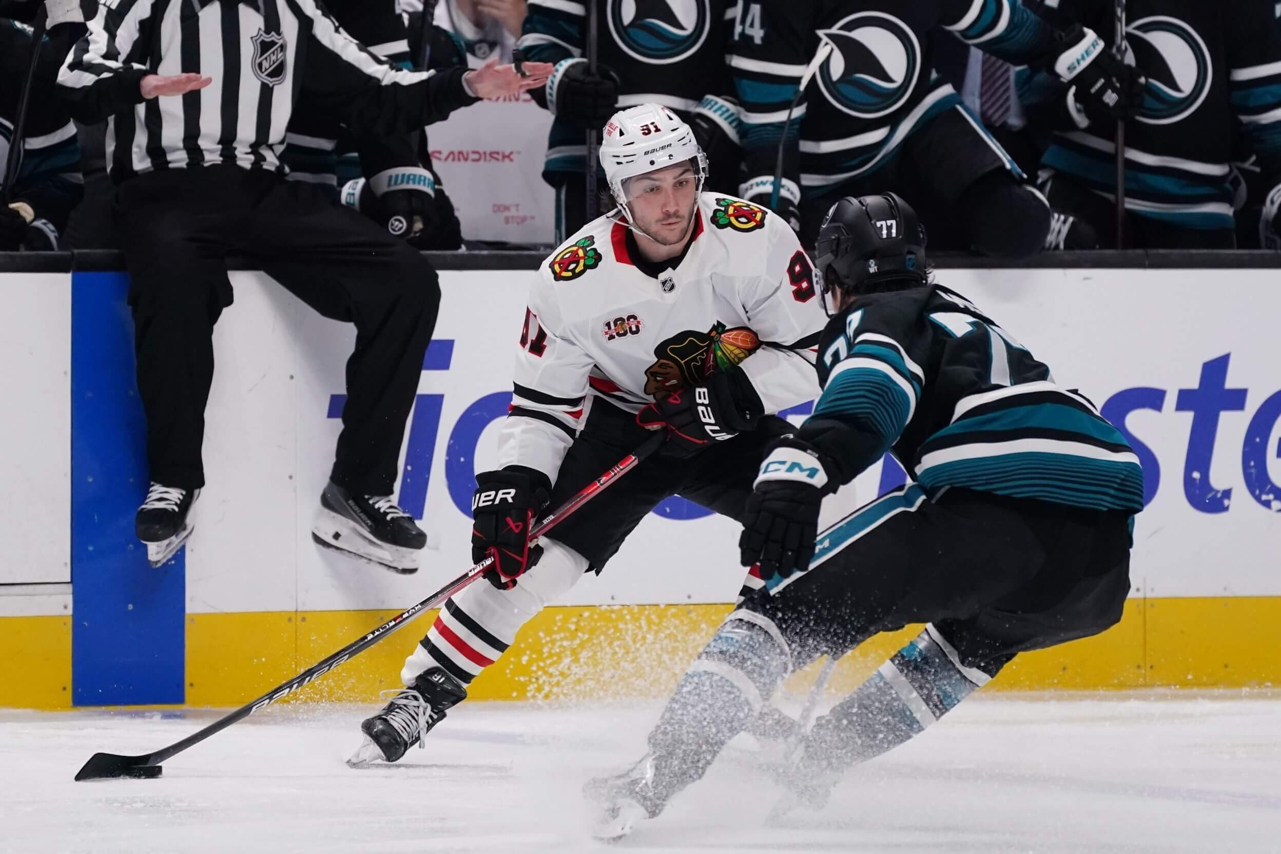 Chicago's Frank Nazar tries to keep the puck from San Jose's Michael Misa.