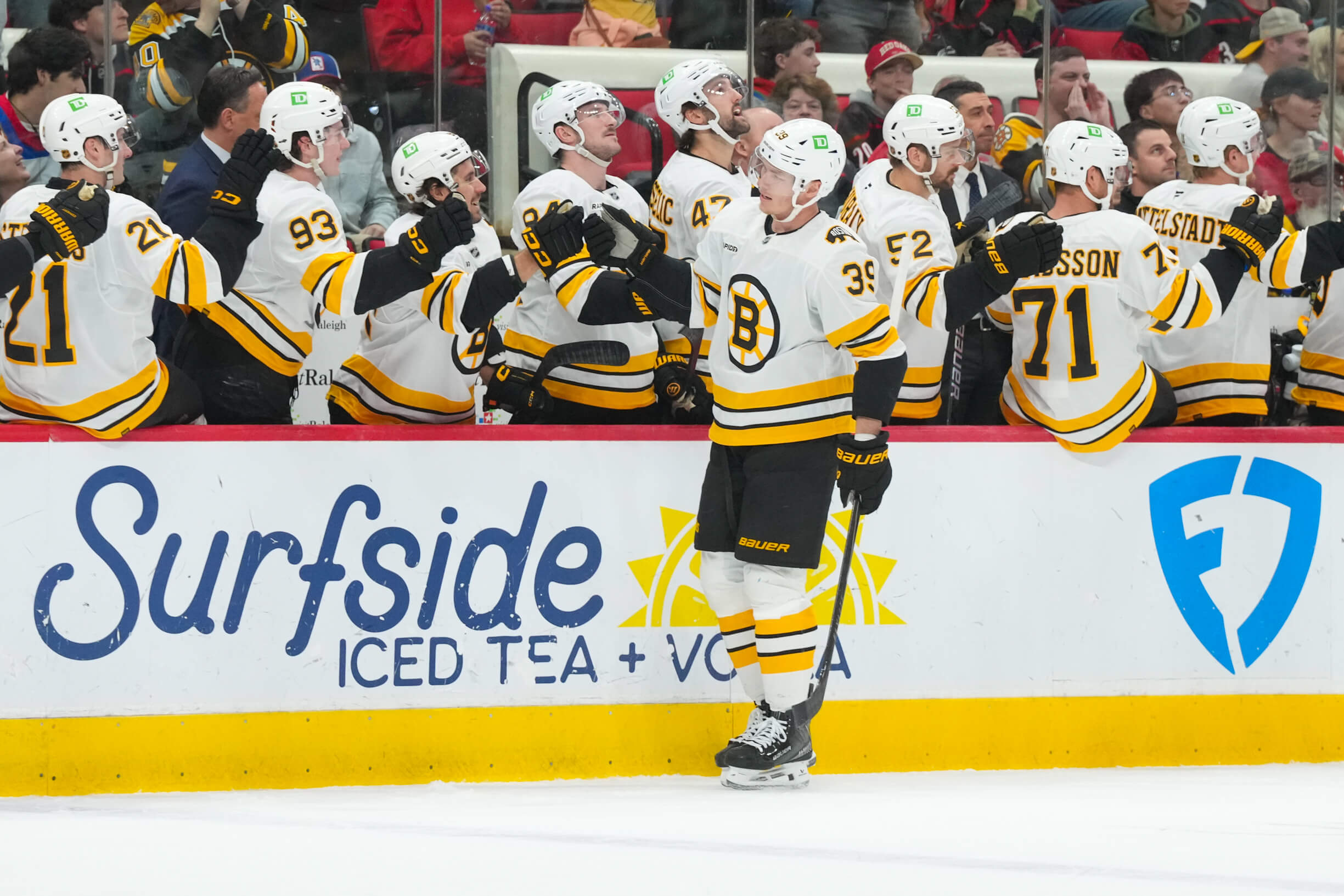 Boston Bruins center Morgan Geekie bumps teammates' fists after scoring.