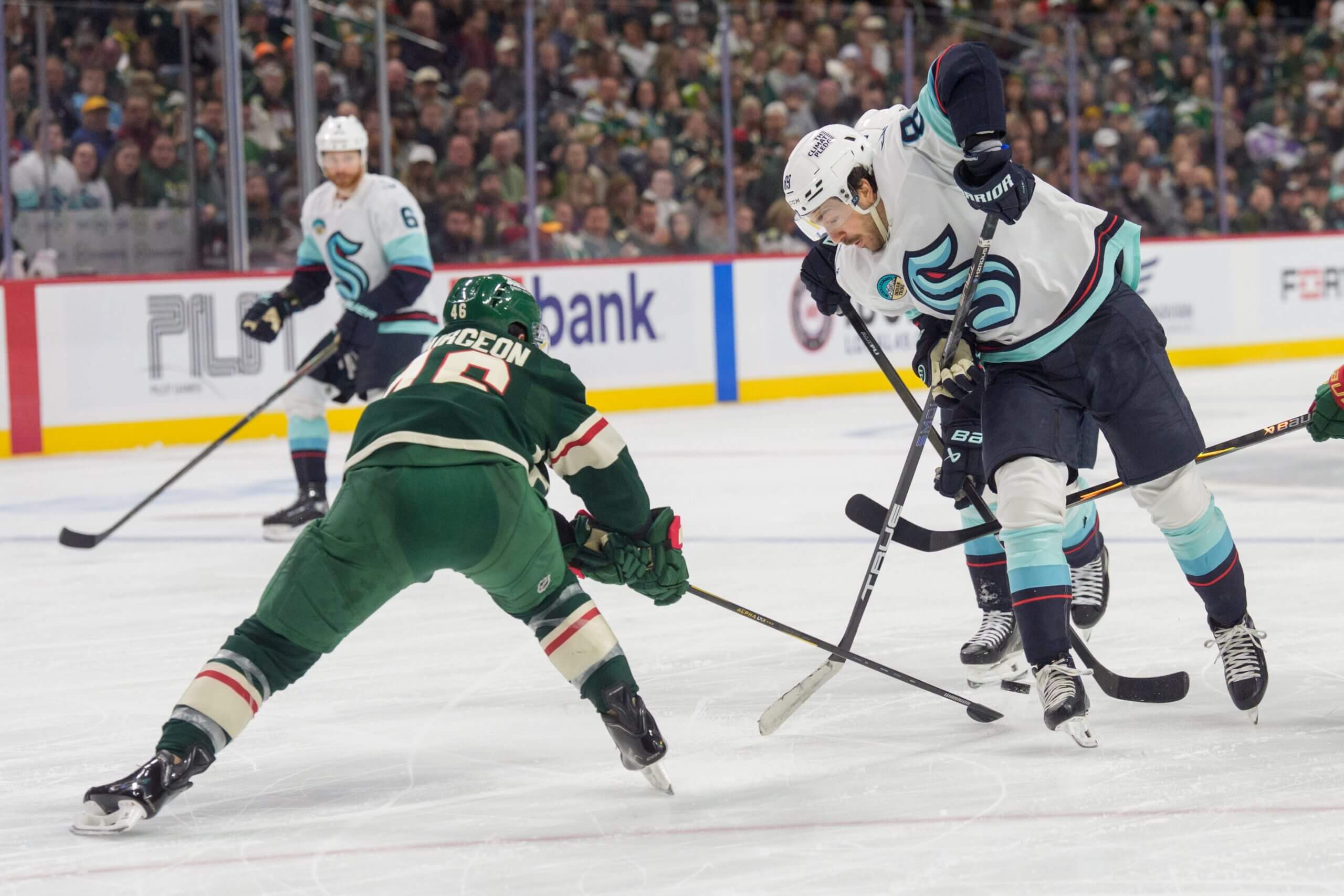 Jared Spurgeon pokes the puck away from Seattle's Freddy Gaudreau.