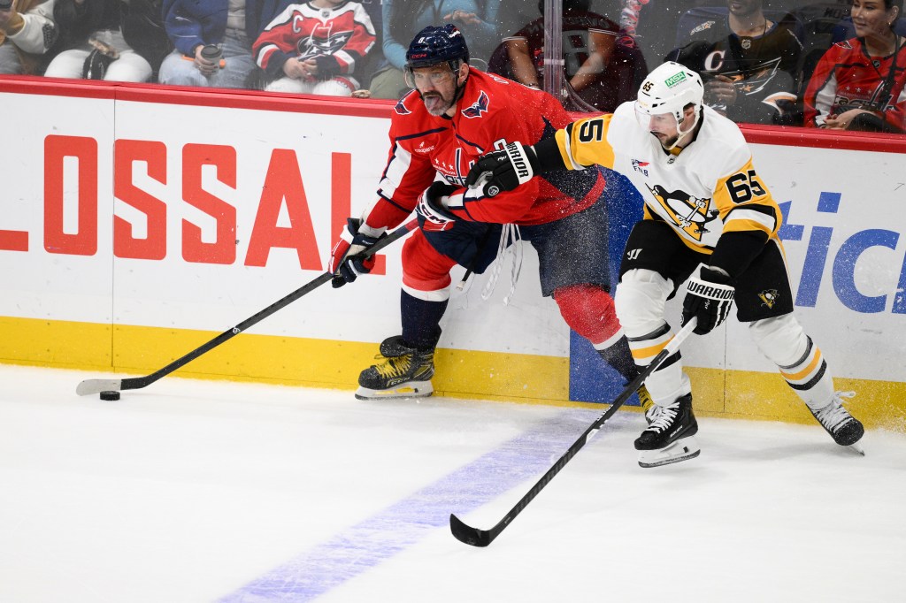 Alex Ovechkin of the Washington Capitals battles Erik Karlsson of the Pittsburgh Penguins for the puck.