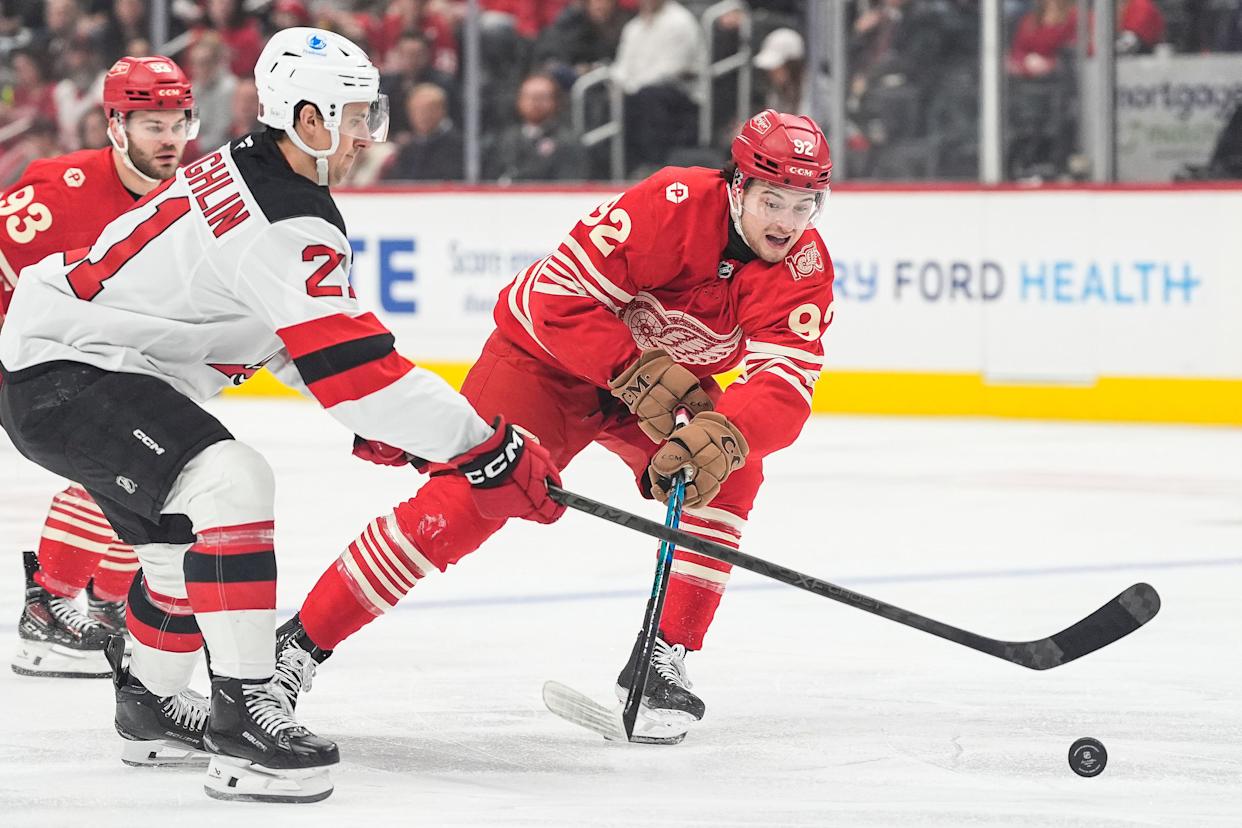 Detroit Red Wings right wing Alex DeBrincat (93) defends New Jersey Devils center Marc McLaughlin (21) during the first period at Little Caesars Arena in Detroit on Saturday, April 11, 2026.