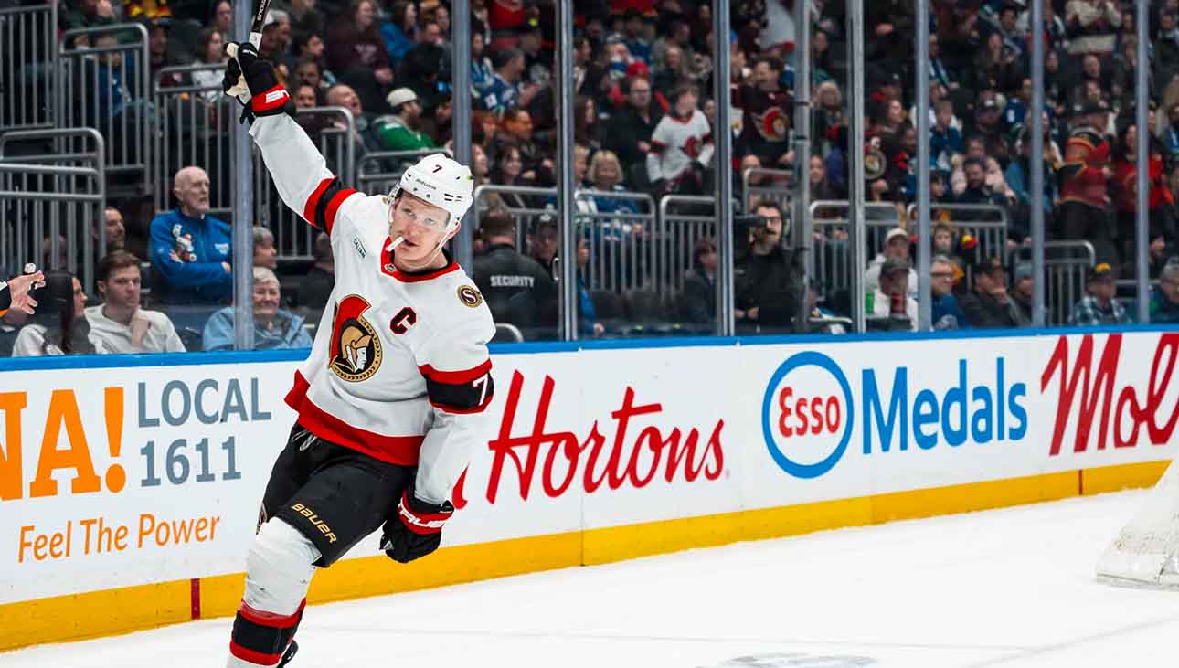 Ottawa Senators captain Brady Tkachuk skating on the ice with his stick raised during a game, amidst escalating NHL trade rumors about his future.