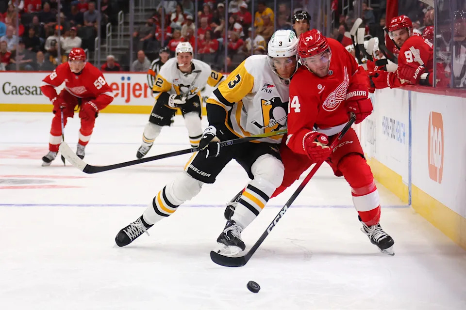 Cartar Mazur of the Detroit Red Wings is checked off the puck by Jack St. Ivany of the Pittsburgh Penguins during a preseason game at Little Caesars Arena on September 29, 2025 in Detroit.
