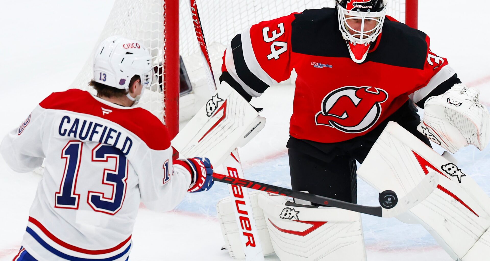 Hockey player shoots at goalie at close range.