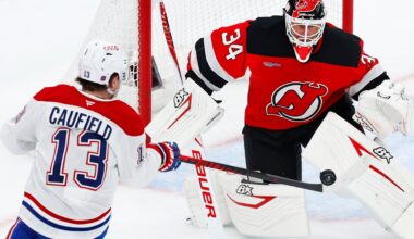 Hockey player shoots at goalie at close range.
