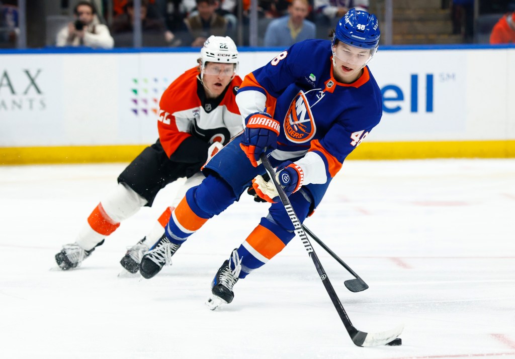 Matthew Schaefer (48) controls the puck against Philadelphia Flyers center Christian Dvorak (22) during the second period of an NHL hockey game, Friday, April 3, 2026 in Elmont, N.Y. 