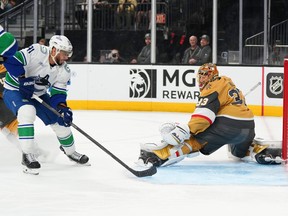 Vancouver Canucks left wing Evander Kane (91) scores against Vegas Golden Knights goaltender Adin Hill (33) during the first period on Monday night in Las Vegas. The Golden Knights won 4-2.
