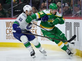 Minnesota Wild centre Joel Eriksson Ek, right, and Vancouver Canucks centre Teddy Blueger compete for the puck.