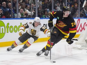 Vancouver Canucks' Zeev Buium (24) skates with the puck away from Vegas Golden Knights' Mitch Marner (93) during the second period at Rogers Arena on Tuesday night