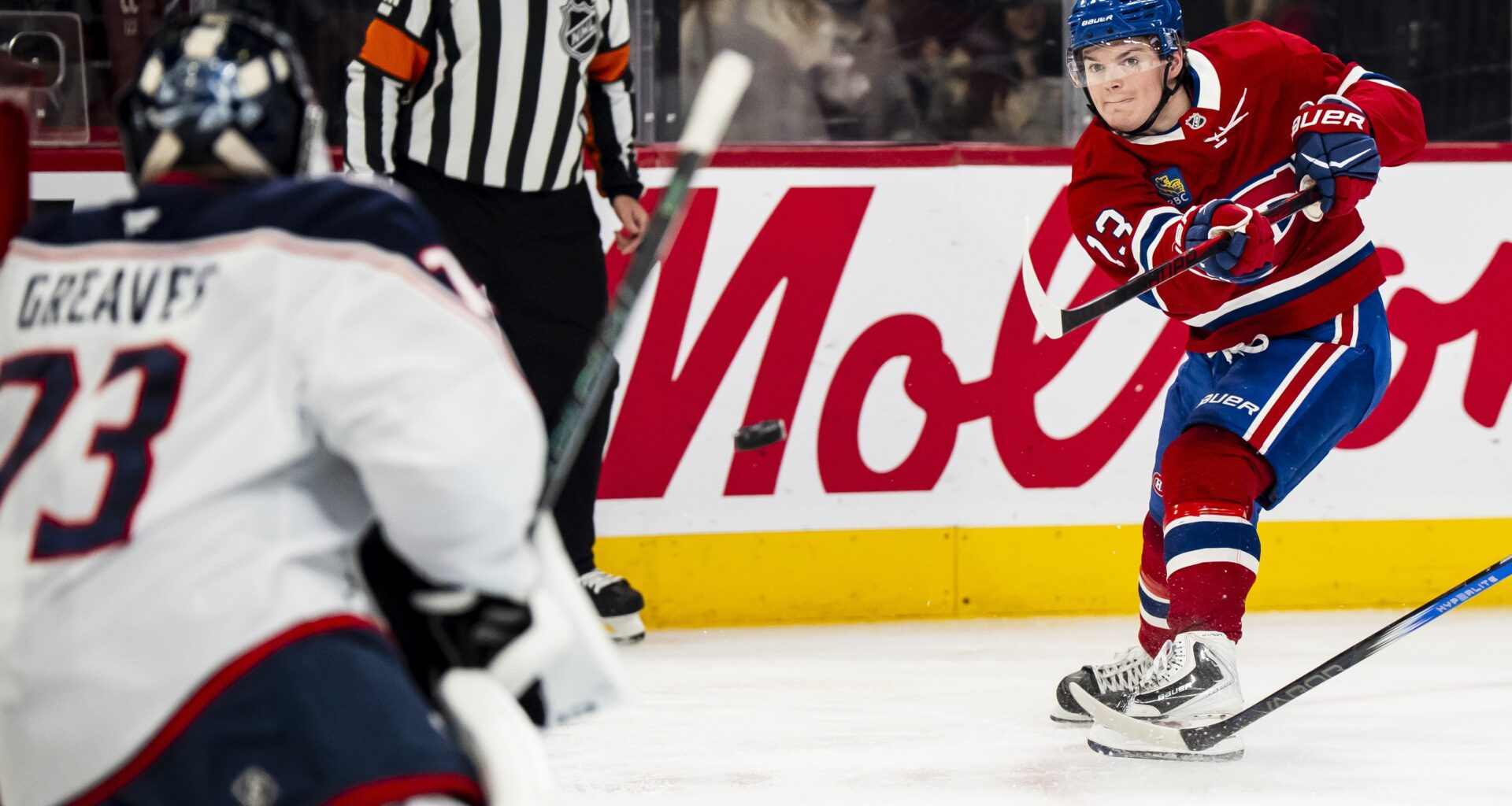 Hockey player whips a shot to score on the goaltender.