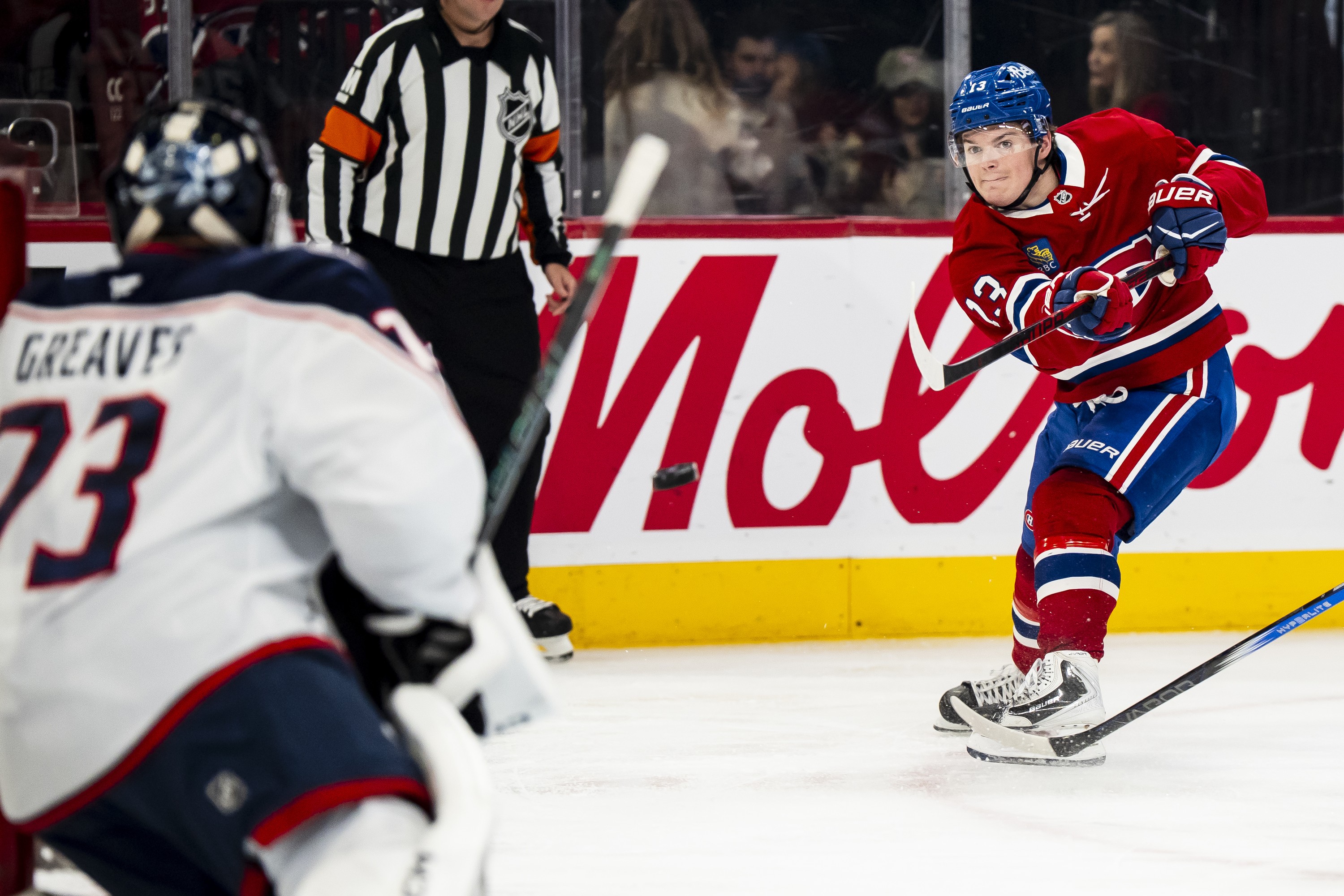 Hockey player whips a shot to score on the goaltender.