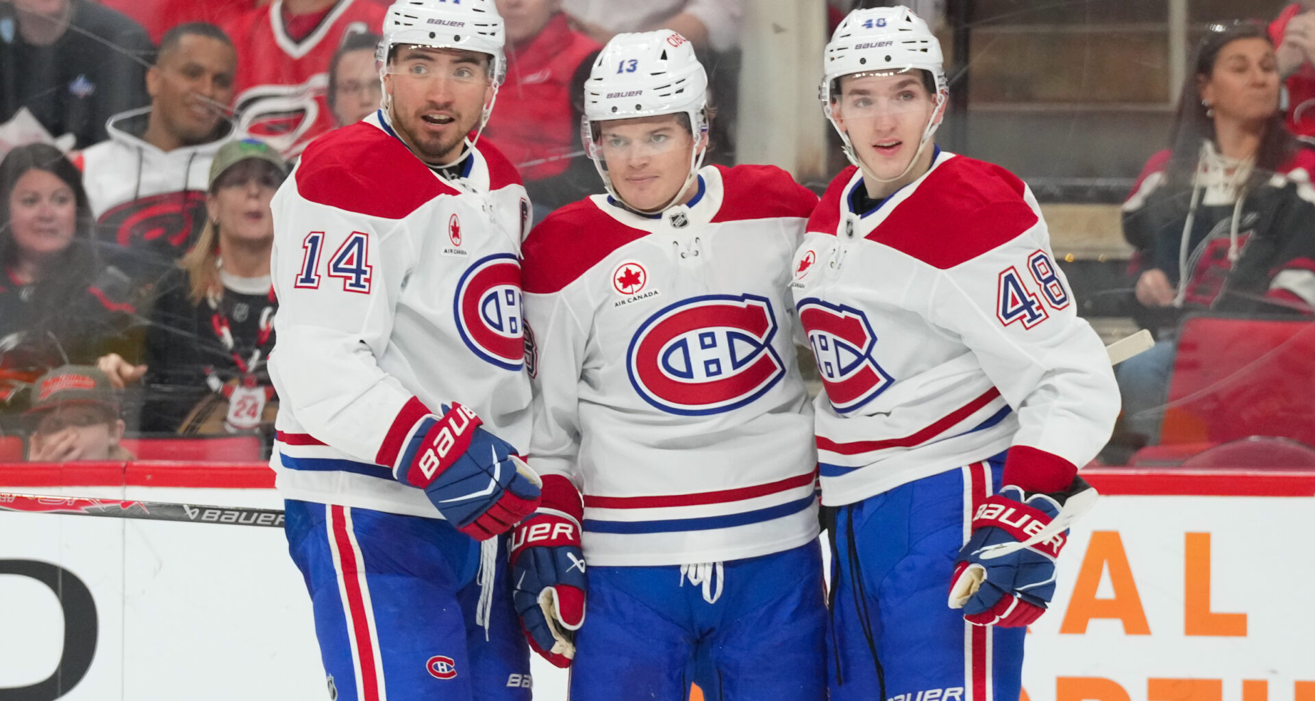 Montreal Canadiens center Nick Suzuki (14) is congratulated by defenseman Lane Hutson (48) and right wing Cole Caufield (13) at Lenovo Center