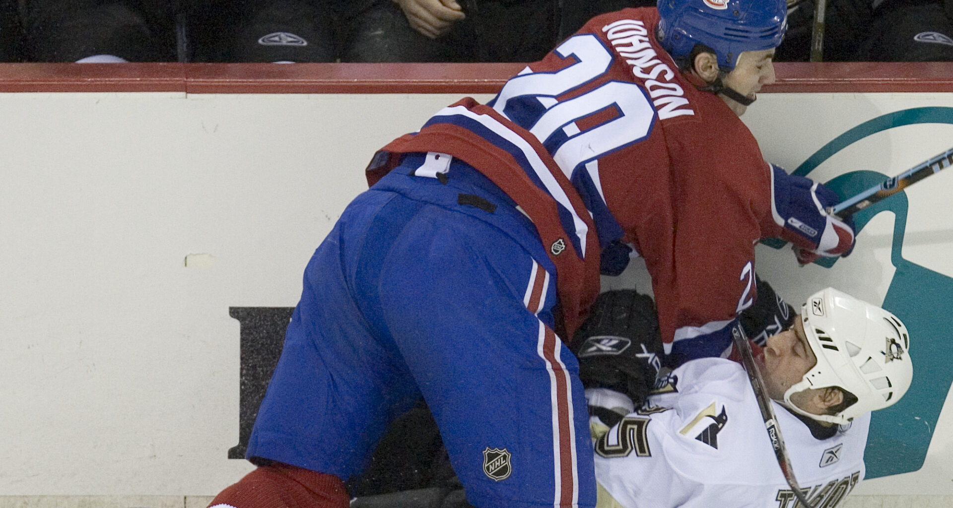 Hockey player checks an opponent intothe boards.