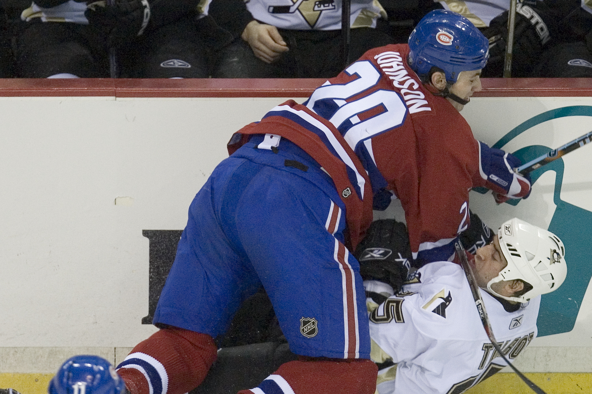 Hockey player checks an opponent intothe boards.