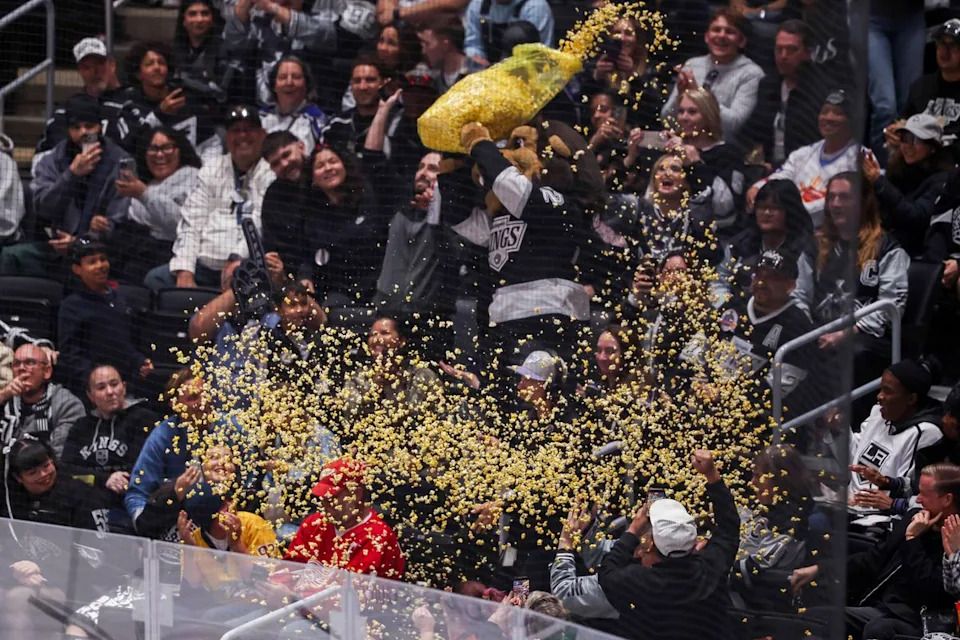 Los Angeles Kings mascot Bailey throws popcorn on fans during an NHL hockey game against the Nashville Predators, Thursday April 2, 2026 in Los Angeles, Calif.