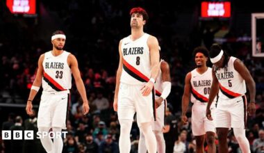 Portland Trail Blazers players Toumani Camara, Robert Williams III, Deni Avdija, Scoot Henderson and Jrue Holiday walk onto the court during a timeout