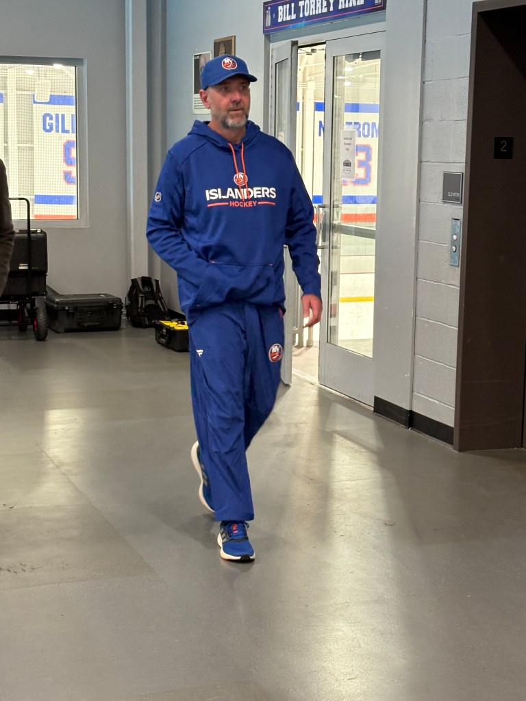 New Islanders coach Peter DeBoer walking in a blue tracksuit.