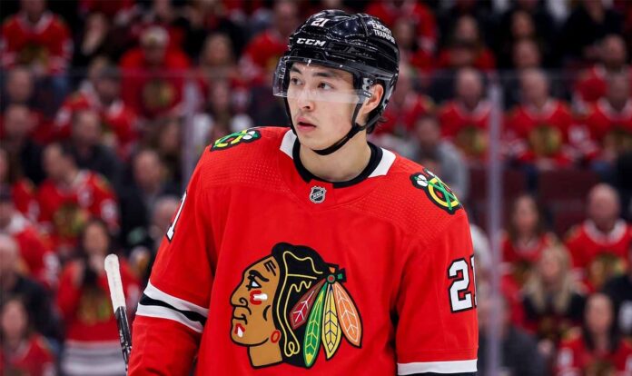 Detailed composite photo of Dallas Stars superstar forward Jason Robertson in a Chicago Blackhawks red home jersey with number 21, on the ice in a packed United Center during a game, illustrating an NHL trade rumor.