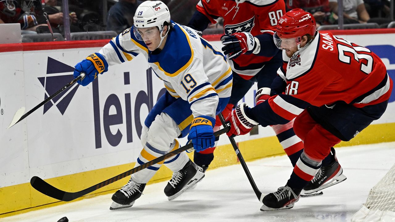 Buffalo Sabres center Peyton Krebs (19) competes for the puck with Washington Capitals defenseman Rasmus Sandin during the second period of an NHL Hockey game, Saturday, April 4, 2026, in Washington. (AP Photo/John McDonnell)