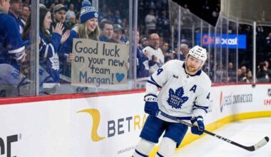 Toronto Maple Leafs defenseman Morgan Rielly skates past a young fan holding a cardboard sign that reads "Good luck on your new team Morgan!" amid persistent trade rumors.
