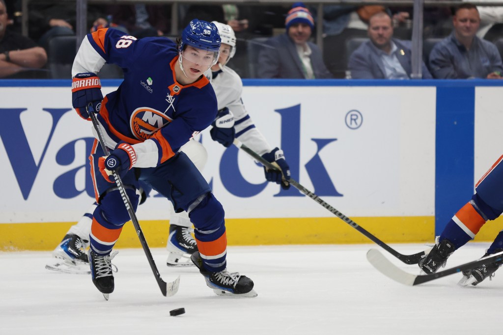 Matthew Schaefer (48) skates with the puck away from Toronto Maple Leafs right wing Easton Cowan (53) during the second period of an NHL hockey game in Elmont, N.Y. on Thursday, April 9, 2026.