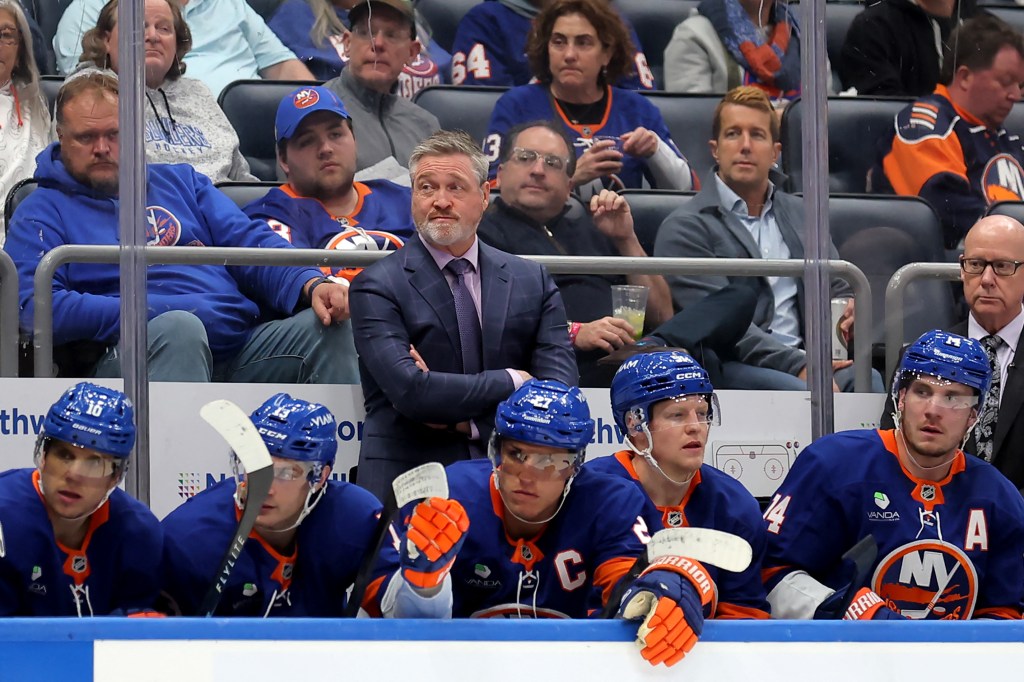 New York Islanders head coach Patrick Roy and players on the bench during a hockey game.