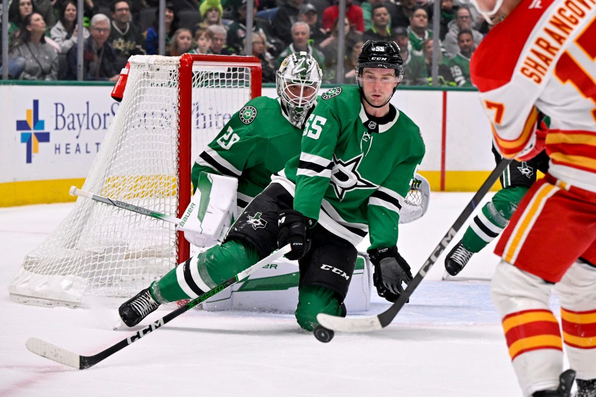 Mar 6, 2025; Dallas, Texas, USA; Dallas Stars defenseman Thomas Harley (55) blocks a shot by Calgary Flames center Yegor Sharangovich (17) as goaltender Jake Oettinger (29) looks on during the third period at the American Airlines Center. Mandatory Credit: Jerome Miron-Imagn Images