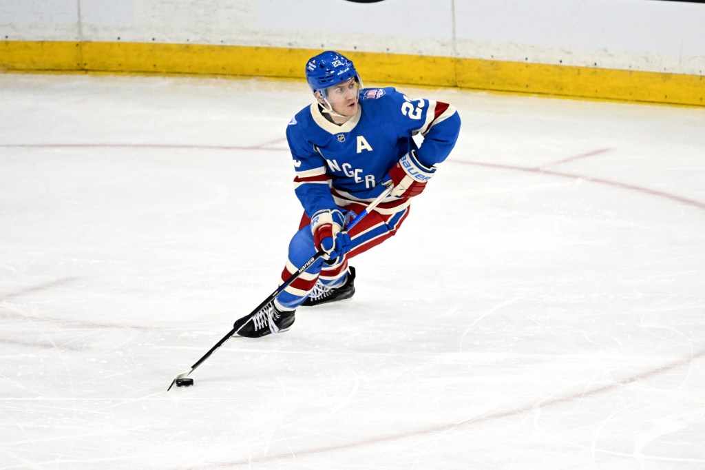 Rangers defenseman Adam Fox (23) skates with the puck.