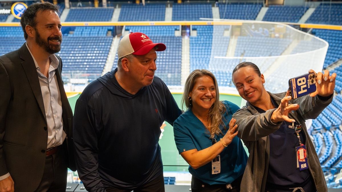 A doctor and nurses pose for a selfie with a patient