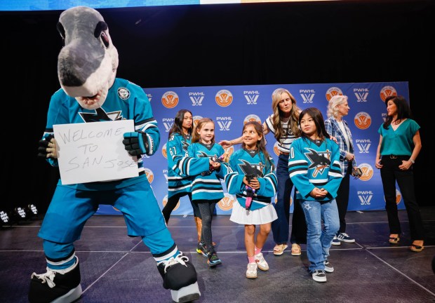 Jr. Sharks hockey players stand on stage with S.J. Sharkie, San Jose Sharks mascot, after a press conference where Professional Women's Hockey League officially announces a team in San Jose at SAP Center in San Jose, Calif., on Tuesday, May 19, 2026. (Shae Hammond/Bay Area News Group)