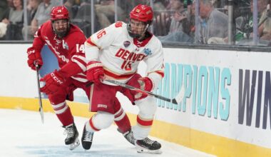 Apr 11, 2026; Las Vegas, Nevada, United States; Wisconsin Badgers defenseman Joe Palodichuk (14) and Denver Pioneers forward Kyle Chyzowski (16) battle for control of the puck during the second period in the championship game of the NCAA men's ice hockey Frozen Four at T-Mobile Arena