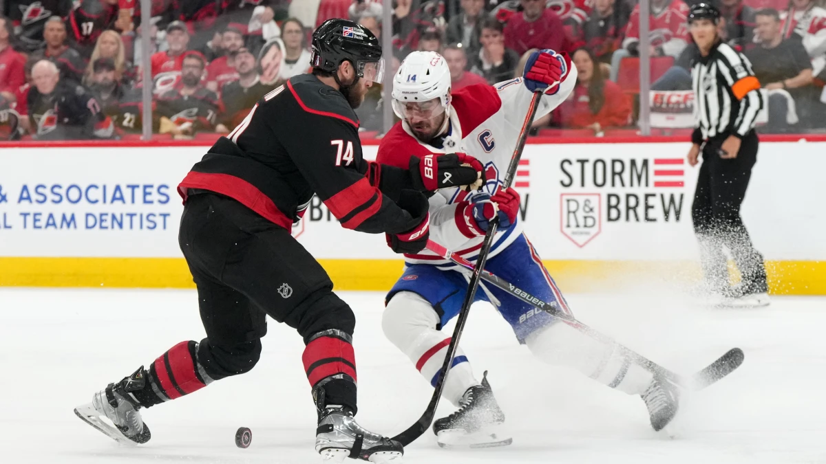 Carolina Hurricanes defenseman Jaccob Slavin (74) challenges Montreal Canadiens center Nick Suzuki (14) for the puck during the second period in game one of the Eastern Conferene Final of the 2026 Stanley Cup Playoffs at Lenovo Center.