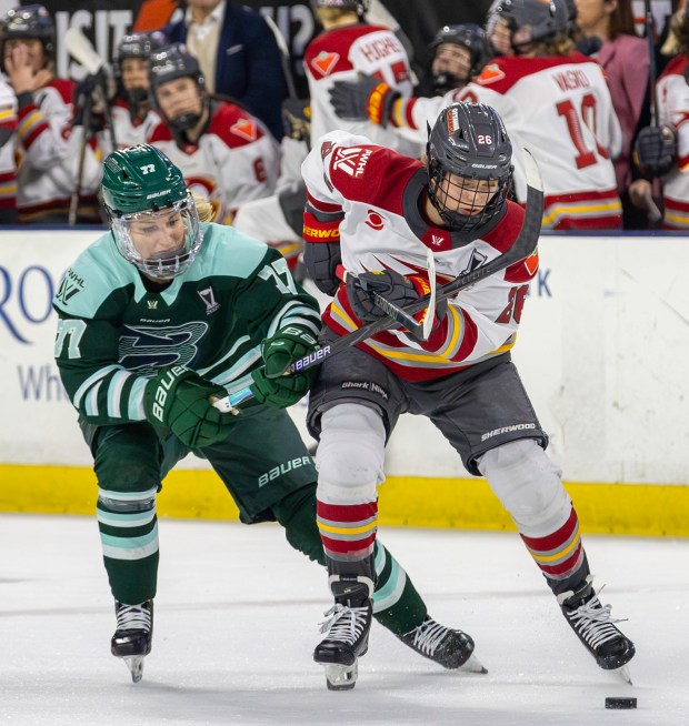 Boston Fleet's Susanna Tapani, left, battles Ottawa Charge's Emily Clark for the puck during Thursday's PWHL Walter Cup semifinal game. (James Thomas for the Lowell Sun)