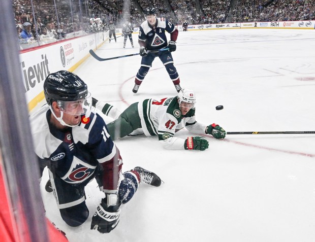 Michael McCarron (47) of the Minnesota Wild falls as he defends Brock Nelson (11) and Nathan MacKinnon (29) of the Colorado Avalanche during the third period of the Avs' shootout win at Ball Arena in Denver, Colorado on Sunday, March 8, 2026. (Photo by AAron Ontiveroz/The Denver Post)