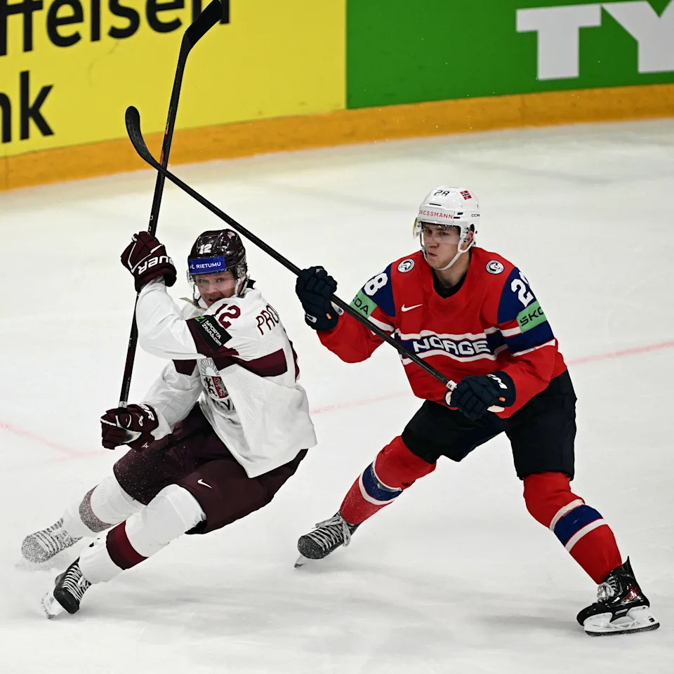 Latvia forward Glebs Prohorenkovs (left) and Norway forward Michael Brandsegg-Nygard vie for the puck during the IIHF Ice Hockey Men's World Championship quarterfinal match in Fribourg, Switzerland.