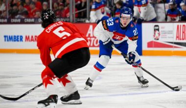 Jan 2, 2026; Minneapolis, Minnesota, USA; Slovakia forward Jakub Dubravik (23) controls the puck as Canada defensemen Carson Carels (5) defends during the first period in the quarterfinals of the 2026 IIHF World Junior Championship at 3M Arena. Mandatory Credit: Nick Wosika-Imagn Images