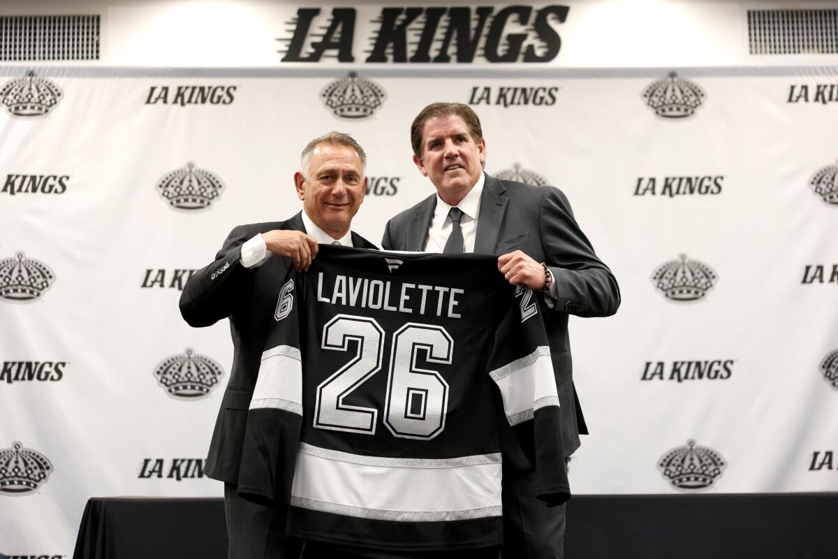 Kings general manager Ken Holland, left, and Peter Laviolette hold up a jersey with the new coach's name on it. 