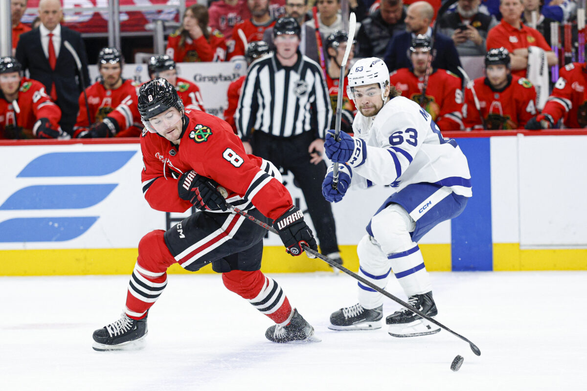 Nov 15, 2025; Chicago, Illinois, USA; Chicago Blackhawks center Ryan Donato (8) battles for the puck with Toronto Maple Leafs left wing Matias MacCelli (63) during the first period at United Center. Mandatory Credit: Kamil Krzaczynski-Imagn Images