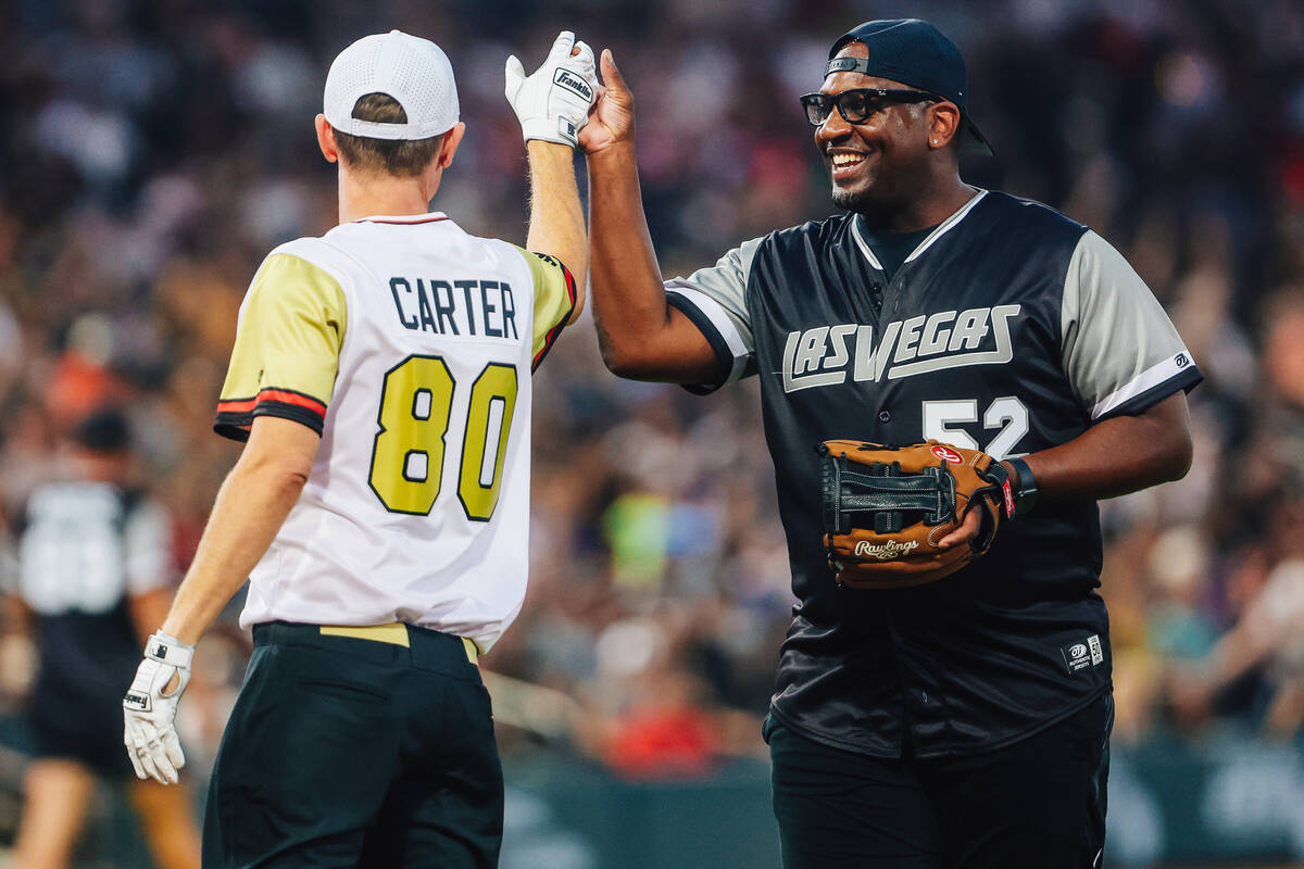 Raiders linebacker Elandon Roberts (52) high-fives Backstreet Boys singer Nick Carter (80) duri ...