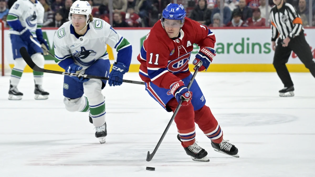 Montreal Canadiens forward Brendan Gallagher (11) plays the puck and Vancouver Canucks forward Brock Boeser (6) defends during the second period at the Bell Centre.
