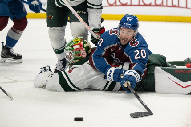 Center Ross Colton (20) of the Colorado Avalanche tries to reach the puck for a rebound while on top of goaltender Jesper Wallstedt (30) of the Minnesota Wild during the first period of Game 5 of the second round of the Stanley Cup Playoffs on Wednesday, May 13, 2026, at Ball Arena in Denver. (Photo by Timothy Hurst/The Denver Post)