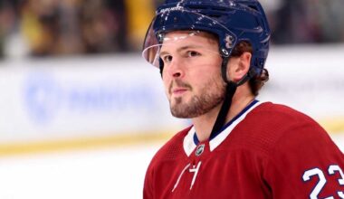 A detailed close-up view of NHL player Mason McTavish wearing a red Montreal Canadiens (Habs) home jersey with the number 23 on the shoulder and a blue Bauer helmet with the 'CH' logo, standing on an ice rink.